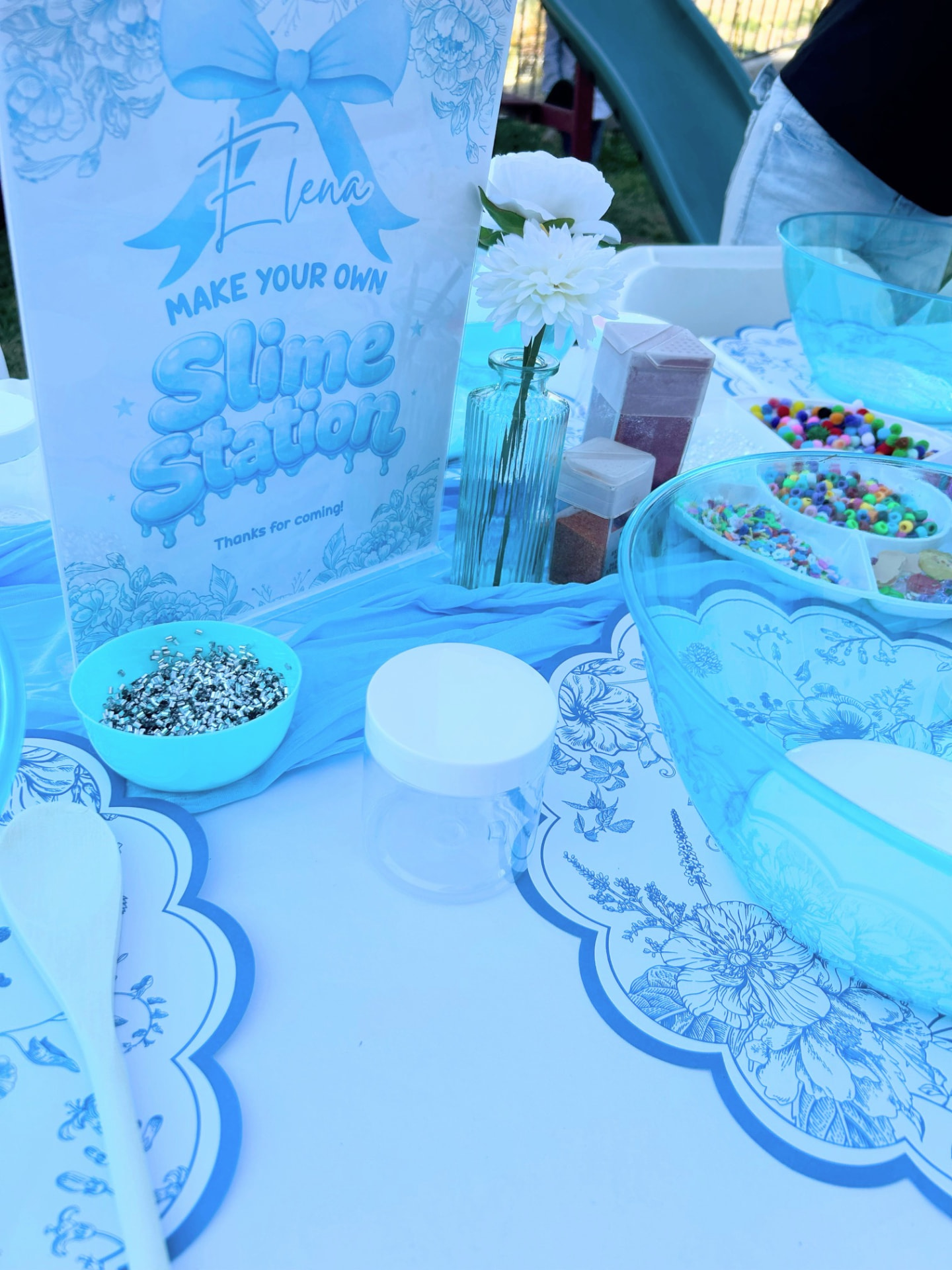 Personalized slime station with beads, glitter, and themed decor